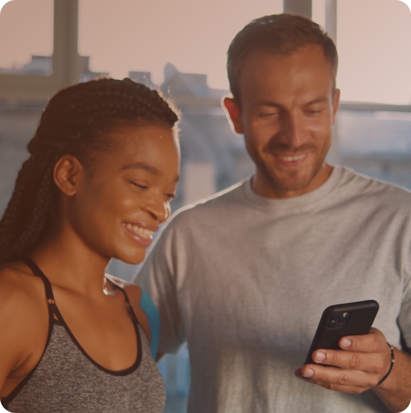 A patient smiling at their phone while a clinician sits beside them.