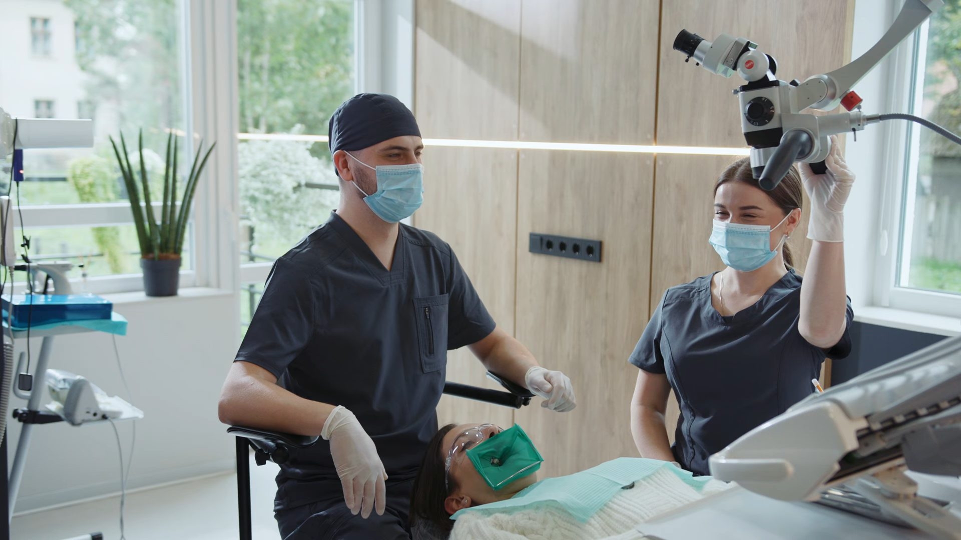 A dentist and a nurse treating a patient in a surgery.
