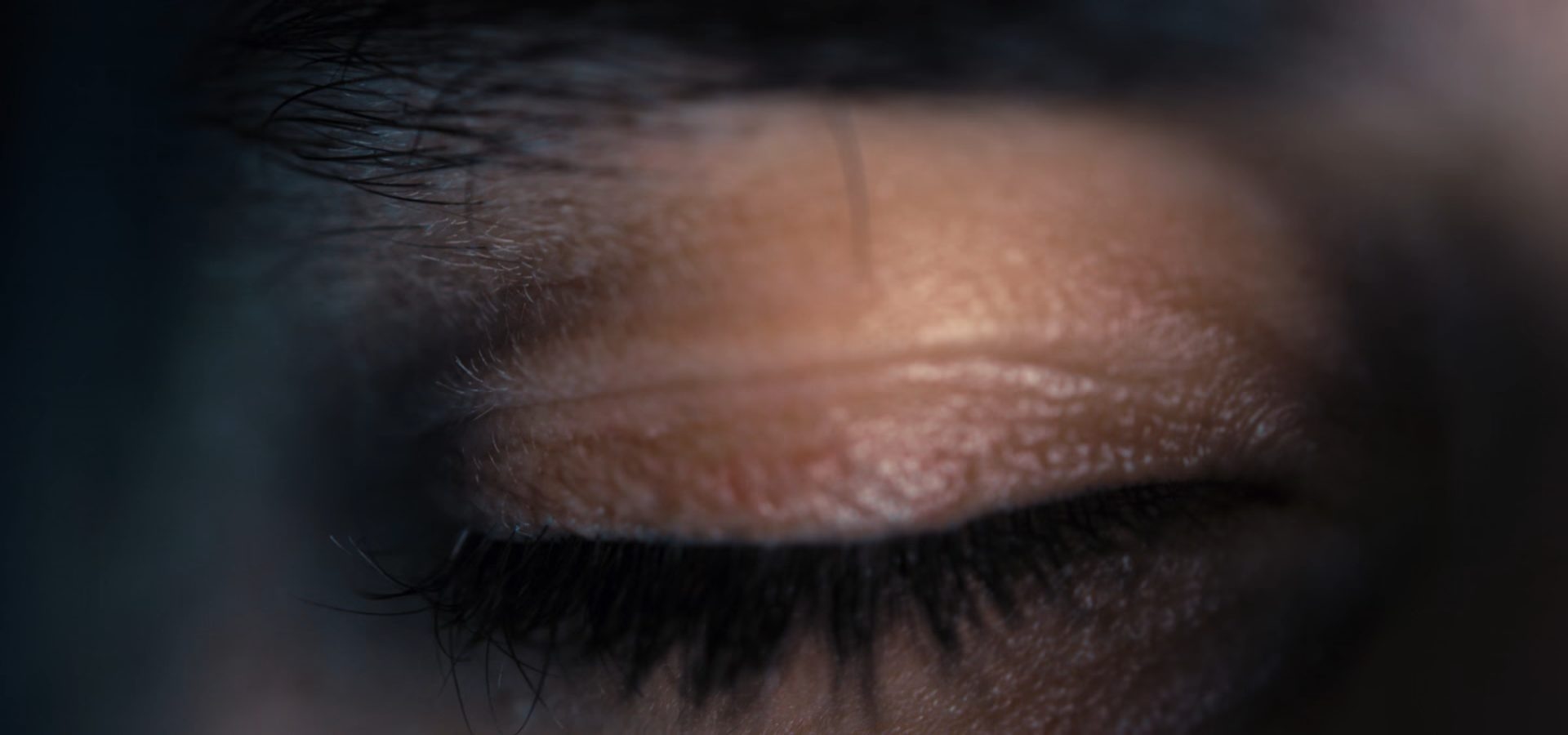 A close view of a patient's eye and brow during an eye examination.